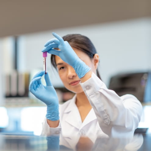 Doctor reviews a test tube in a lung cancer laboratory.