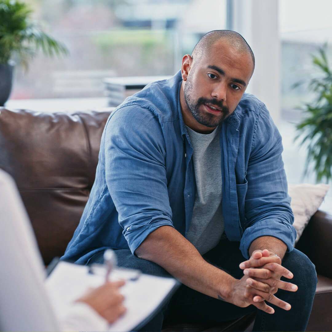 Cancer patient listens intently as a financial counselor explains payment options in a bright office setting